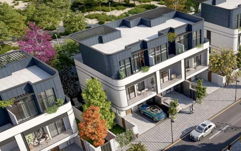 White-facade villas and townhouses with greenery at Taormina Village, a Reportage Properties community in Dubai